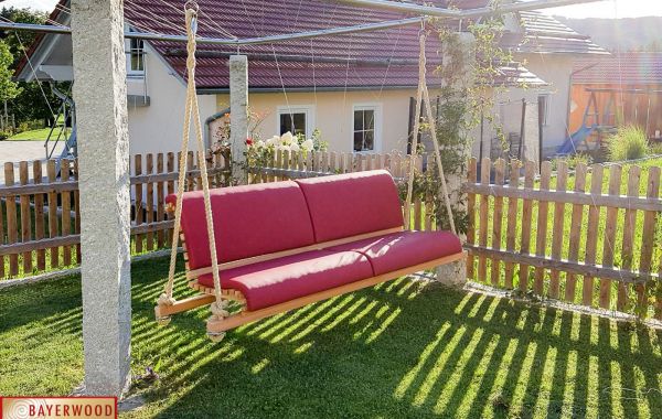 Haengeschaukel fuer den Garten mit roter Auflage