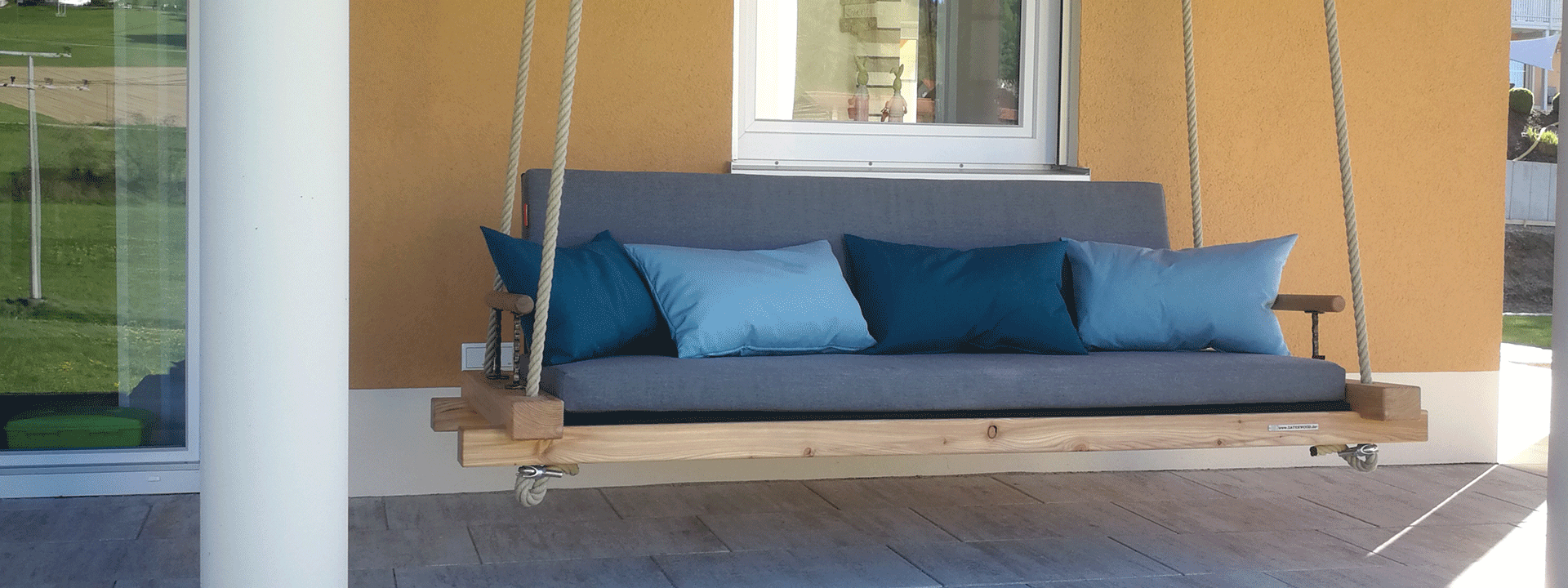 Terrassenschaukel aus Holz mit grauer Auflage